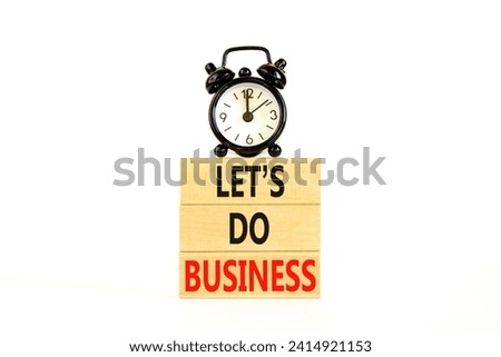 let is do business symbol. Concept words let is do business on beautiful wooden blocks. Beautiful white table white background. Black alarm clock. let is do business concept. Copy space.