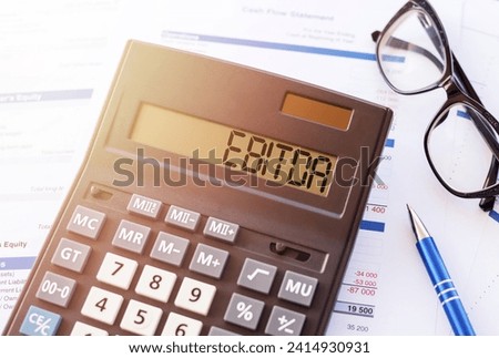 EBITDA (abbreviation of earnings before interest, taxes, depreciation and amortization) word written on calculator screen. Concept for your design. Royalty-Free Stock Photo #2414930931