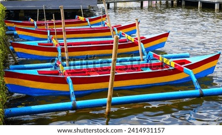 Colorfully Painted Traditional Boats Lined Up for Participation in Diverse Local Celebrations