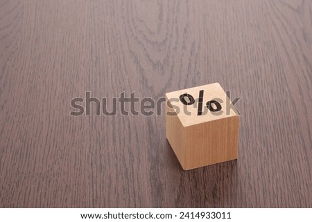 wooden blocks with sign percent over a brown background with copy space. this concept suggests a visual approach to conveying financial or statistical information