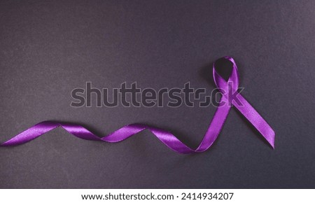 Purple ribbon isolated on white background with cutouts to raise awareness of animal cruelty,Alzheimer's disease, domestic violence, epilepsy, lupus, sarcoidosis, Crohn's disease and pancreatic cancer Royalty-Free Stock Photo #2414934207