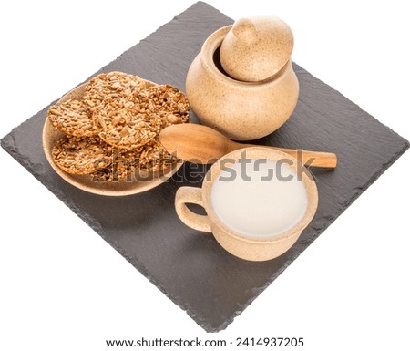 Several Thaler cookies on a slate stone with a cup of sour cream and a sugar bowl, macro, isolated on a white background.