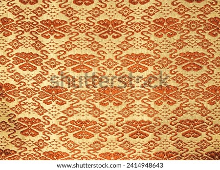 Vintage flowers of Thai style fabric pattern. Gold brown tone. Abstract  horizontal seamless fabric background and texture. beautiful patterns, space for work, vintage wallpaper, close up.