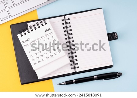 March 2024 calendar, notepad, pen and computer keyboard Royalty-Free Stock Photo #2415018091