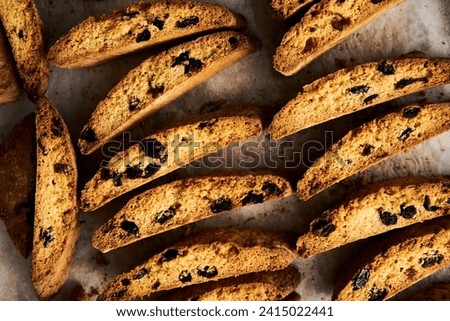 Golden Biscotti or Cantuccini on the baking pan. Traditional Sweet Italian cookies that are making with two times baking, with nuts and dried cranberries. Extra crunchy and dry. Top view Royalty-Free Stock Photo #2415022441