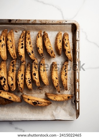 Golden Biscotti or Cantuccini on the baking pan. Traditional Sweet Italian cookies that are making with two times baking, with nuts and dried cranberries. Extra crunchy and dry. Top view Royalty-Free Stock Photo #2415022465