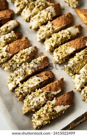 Golden Biscotti or Cantuccini on the baking pan. Traditional Sweet Italian cookies that are making with two times baking, with nuts and dried cranberries. Extra crunchy and dry Royalty-Free Stock Photo #2415022499