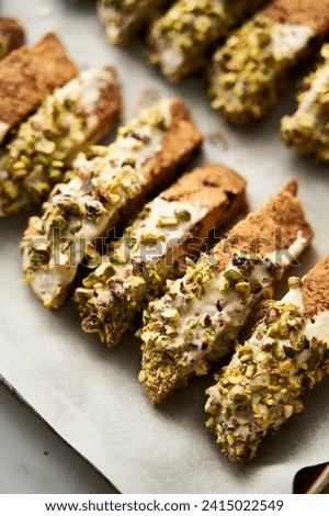 Golden Biscotti or Cantuccini on the baking pan. Traditional Sweet Italian cookies that are making with two times baking, with nuts and dried cranberries. Extra crunchy and dry Royalty-Free Stock Photo #2415022549