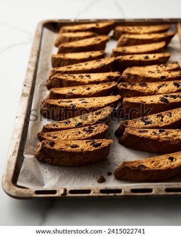 Golden Biscotti or Cantuccini on the baking pan. Traditional Sweet Italian cookies that are making with two times baking, with nuts and dried cranberries. Extra crunchy and dry Royalty-Free Stock Photo #2415022741