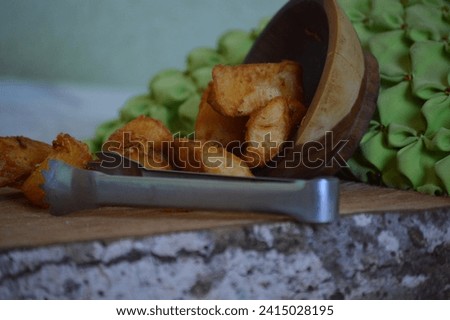 Fried cassava served on a rustic wooden board. Delicious recipe for cassava or fried cassava, a traditional dish of Brazilian cuisine