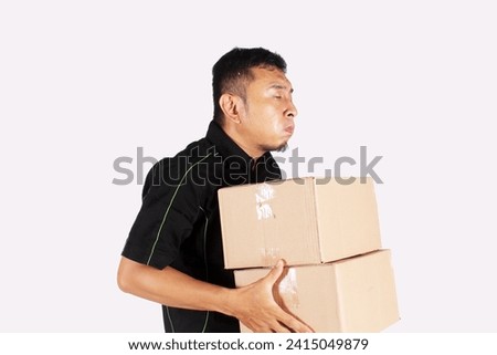 Man Carrying Pile of Heavy Cardboard Boxes Isolated with shock and wow expression