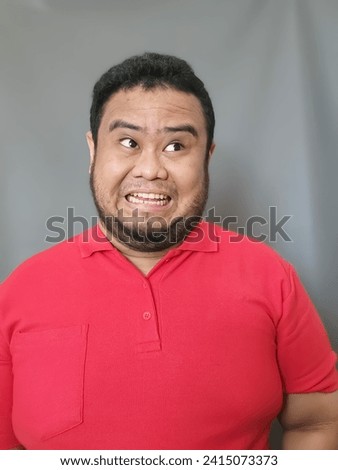 Asian men wearing red T-shirts show funny facial expressions