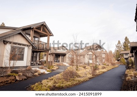 A cluster of modern two story houses in Bend, Oregon in winter. A community of wooden houses with nice landscaping Royalty-Free Stock Photo #2415091899