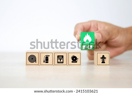 Fire prevention concept on cube wooden toy block stack with door exit sing or fire escape for prevent with fire extinguisher and emergency protection symbol for safety and rescue in the building.