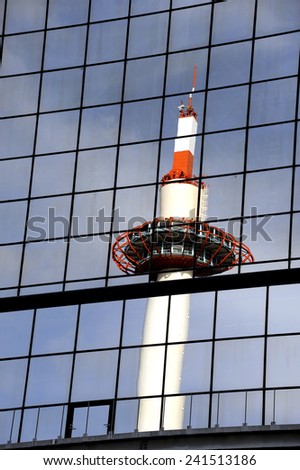 Kyoto Tower mirrored in glass steel building. Taken at Kyoto railway station, Japan.