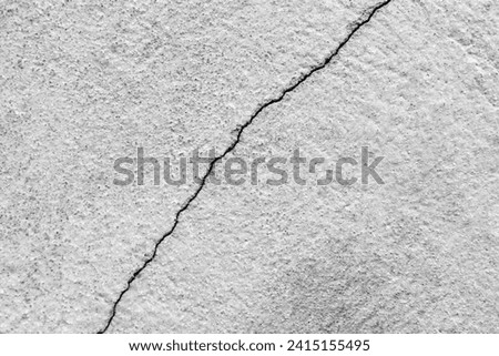 Big crack on old plastering wall. Long winding ascending crack in cement surface of an old building. Copy space. Selective focus. Royalty-Free Stock Photo #2415155495