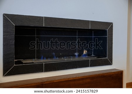 Cozy gas fireplace in the living room of a rural hotel, radiating warmth and charm, inviting moments of serenity by the dancing flame. Royalty-Free Stock Photo #2415157829