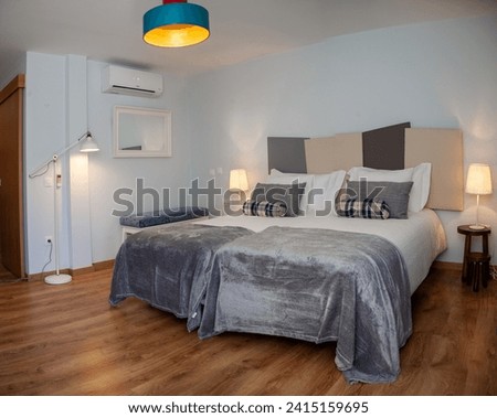 Cozy double bedroom in a contemporary rural hotel, featuring elegant decor and a relaxing atmosphere. Ideal for romantic getaways. Royalty-Free Stock Photo #2415159695