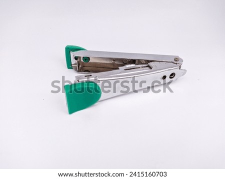 Close-up photo of an green stapler, office stationery for study and work purposes on a white background