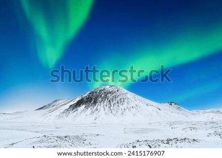 Aurora Borealis. Northern Lights over the mountains. Scandinavia. Winter night landscape with bright lights in the sky. Landscape in the north in winter time. 