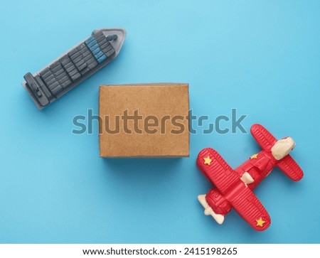 Flatlay picture of airplane and vessel miniature with carton box. Choose delivery shipment concept