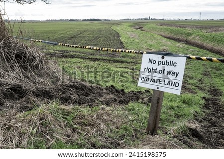 Private Land sign seen at the entrance to a closed farm entrance. Following recent trespassers the farm has had a sign a rope blocking off access to the arable field.