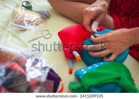 Serene Mid Adult Caucasian Woman Sewing and Creating Textile Toys at Home as Holidays Presents fro Children - Hands Close Up