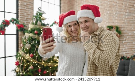 Man and woman couple celebrating christmas make selfie by smartphone at home