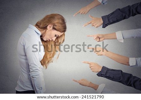 Concept of accusation of guilty businesswoman. Side profile portrait sad upset woman looking down many fingers pointing at her isolated grey office background. Human face expression emotion feeling Royalty-Free Stock Photo #241521790