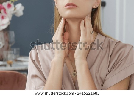 Caucasian woman touching her throat. Sore throat, cold, flu, tonsillitis or thyroid gland problem Royalty-Free Stock Photo #2415221685