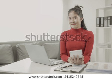 Asian woman using calculator and laptop to do finance, accounting, statistics and analytical research concept to calculate business principles, accounting statistics at office