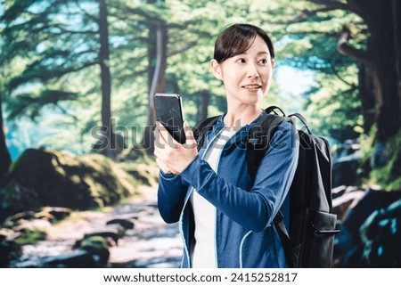 Young woman taking a picture with her phone while hiking