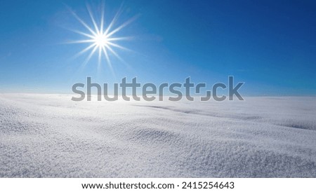 Winter landscape of untouched snow with blue sky and sun star