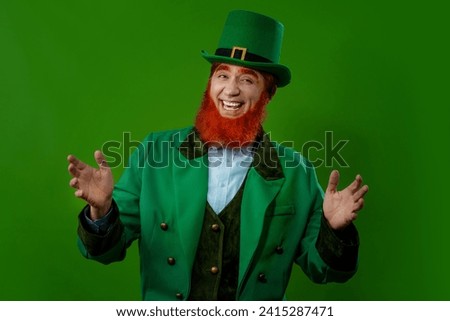 Leprechaun elf symbol of St. Patrick's Day. Cheerful character Irish leprechaun with a red natural beard in a green suit and green hat for advertising. Cosplay at the festival on March 17th.
