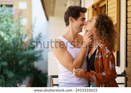Romantic young couple caressing on balcony of modern building Royalty-Free Stock Photo #2415333623