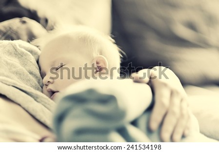 Sleeping baby in mother's arms.