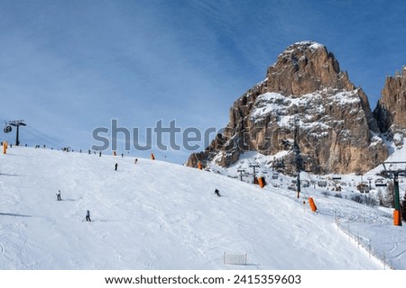 Ski resort in the Dolomites. Mountain recreation place. Ski slopes in the Dolomites on a clear sunny day. Alpine skiing sport and recreation. Royalty-Free Stock Photo #2415359603