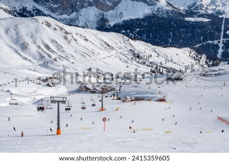 Ski resort in the Dolomites. Mountain recreation place. Ski slopes in the Dolomites on a clear sunny day. Alpine skiing sport and recreation. Royalty-Free Stock Photo #2415359605