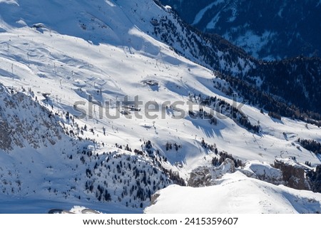 Ski resort in the Dolomites. Mountain recreation place. Ski slopes in the Dolomites on a clear sunny day. Alpine skiing sport and recreation. Royalty-Free Stock Photo #2415359607