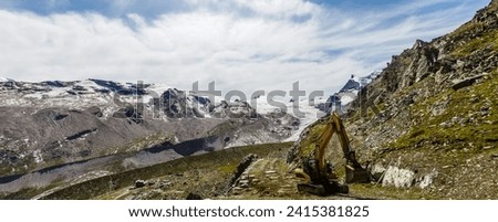 Road construction in mountains, excavator in the mountains. Royalty-Free Stock Photo #2415381825