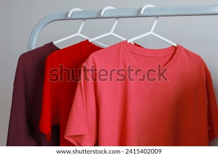 Plain colorful t-shirts mockup hanging on rack clothes over white background