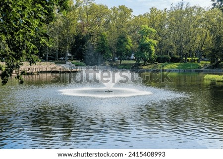 Water fountain in lake with bridge in public park in Budapest, Hungary.