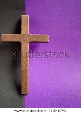 Lent Season, Holy Week, Good Friday, Easter Sunday Concept. Close up of wooden cross with black and purple colours background. For copy space.