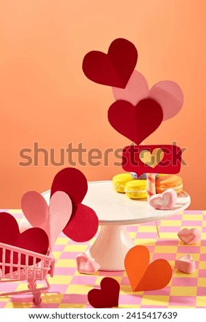 A tray featured marshmallows and colorful macaroons with an empty space. Origami heart papers in pink, red and orange displayed. Vacant space for product promotion Royalty-Free Stock Photo #2415417639