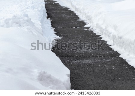 Sidewalk with salt for melting snow in winter. Road during cold snowy weather.