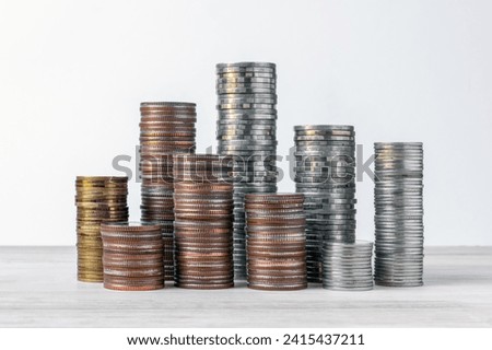 coins stacked on wooden with black background. Concept of saving money, economy, investment, growing business and wealth.