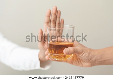 Alcoholism, hand of refuse alcoholic beverage, drink whiskey while person holding glass give to her. Treatment of alcohol addiction, having suffered abuse problem alcoholism isolated on background. Royalty-Free Stock Photo #2415437779