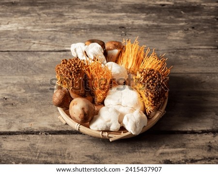 Various types of mushrooms on a wooden plate Royalty-Free Stock Photo #2415437907