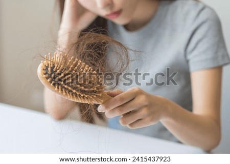 Stress asian young woman, girl hand holding comb show her hairbrush with loss, hair in brush after brushing, hair fall out problem. Health care, beauty with treatment concept, isolated on background. Royalty-Free Stock Photo #2415437923