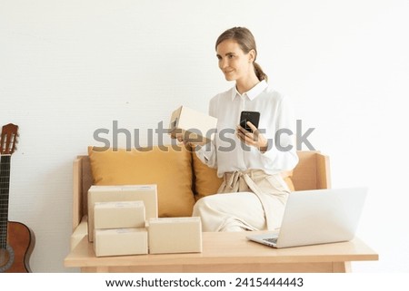 Woman packing to deliver parcels to customers who order in an online store. Check and confirm orders with customers